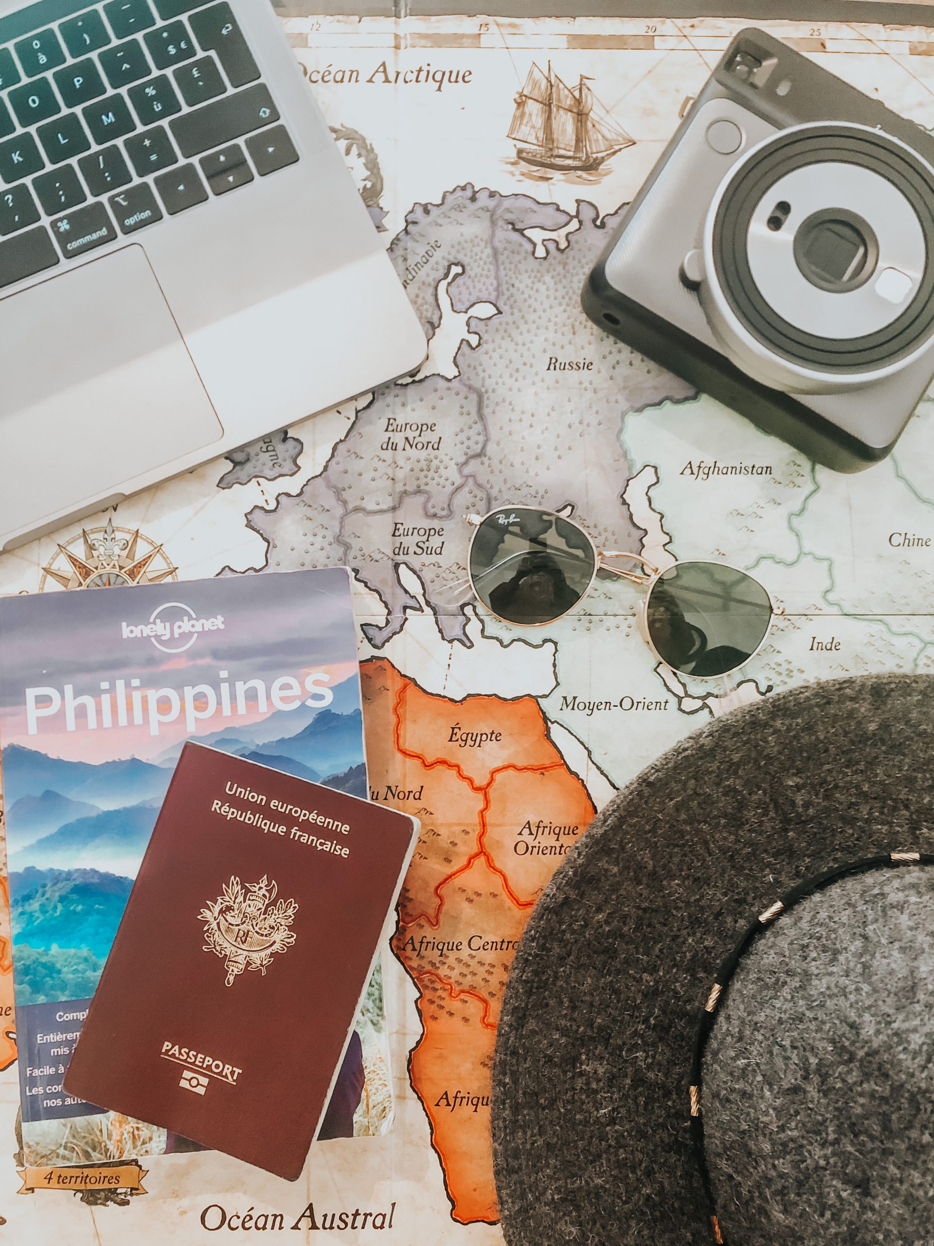 Passeport, carte du monde, ordinateur, lunettes de soleil.